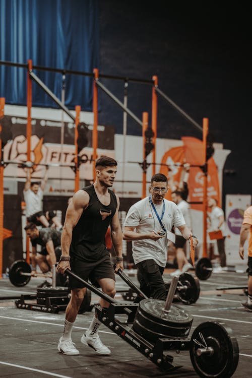 Athlètes en compétition HYROX soulevant des poids en salle